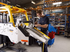 Technician assembling a Power Stow conveyor unit in production